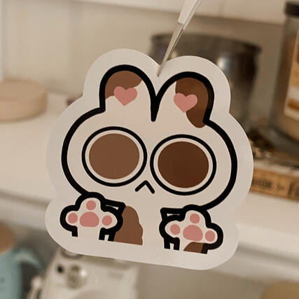 An illustrative kiss-cut sticker of a white bunny with large staring heterochromatic eyes.